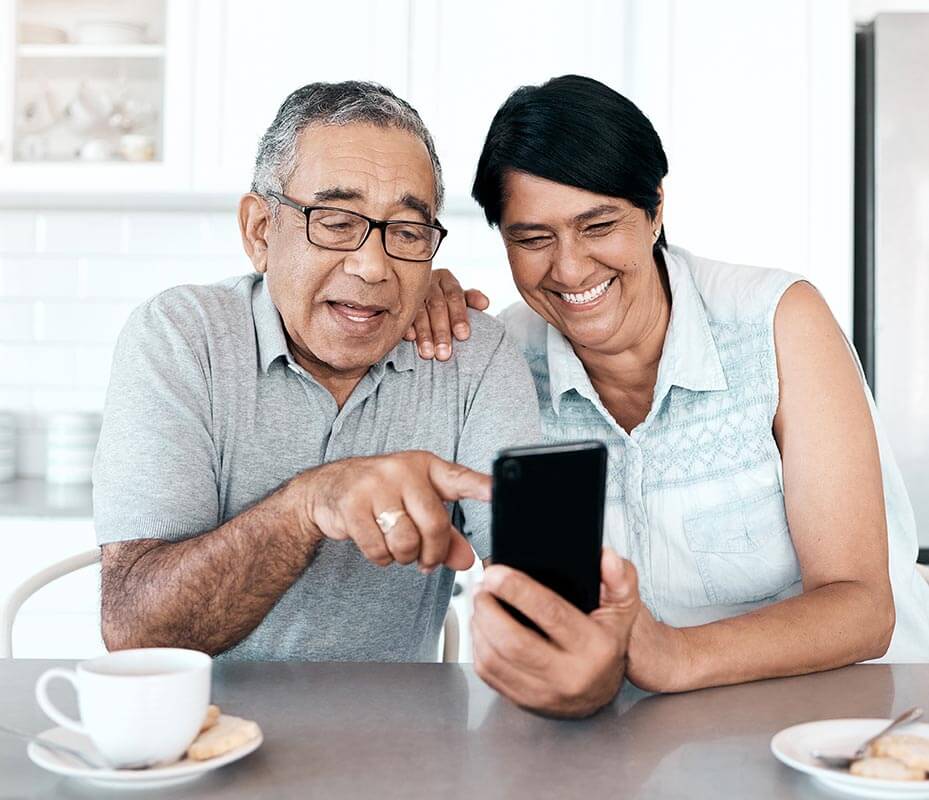 Laughing couple looking at mobile phone